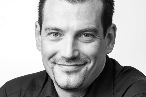 Tobias Schneider Gesicht eines sympathisch lächelnden Mannes mittleren Alters mit kurzen dunklen Haaren und Bart
